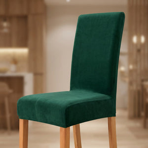 Housse de chaise verte en velours moelleux sur une chaise de salle à manger