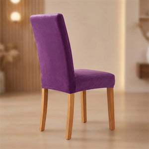 Housse de chaise violette en velours moelleux sur une chaise de salle à manger