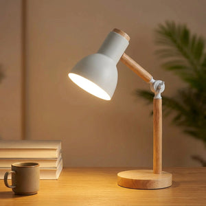 Lampe de bureau articulée en bois avec tête blanche allumée sur un bureau