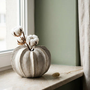 Vase céramique rond crème avec branches coton blanches sur marbre