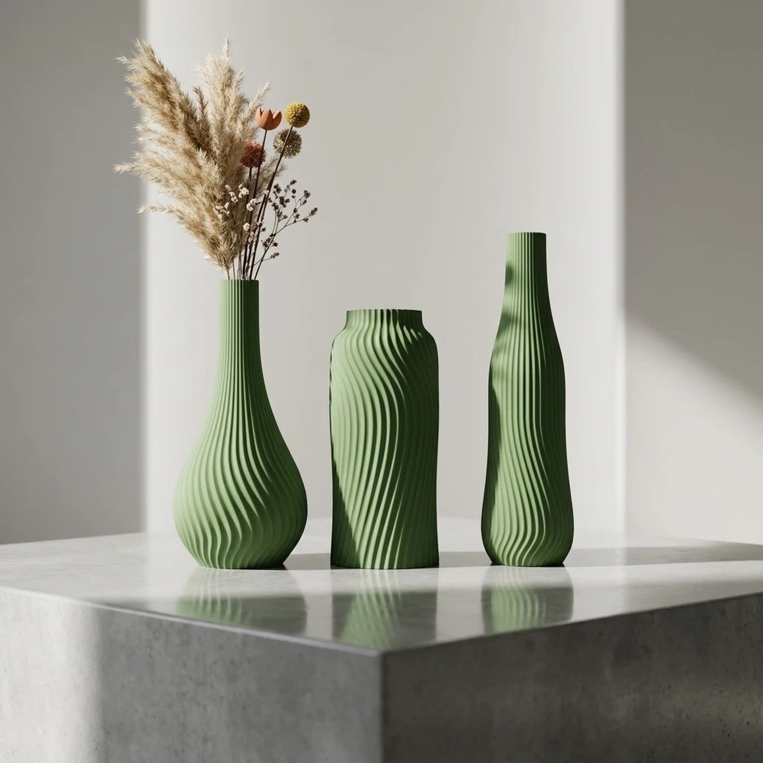 Lot de 3 vases côtelés vert foncé mat avec pampa et fleurs séchées sur table marbre