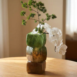 Gros plan sur le verre marbré vert et ambré du vase géométrique empilable