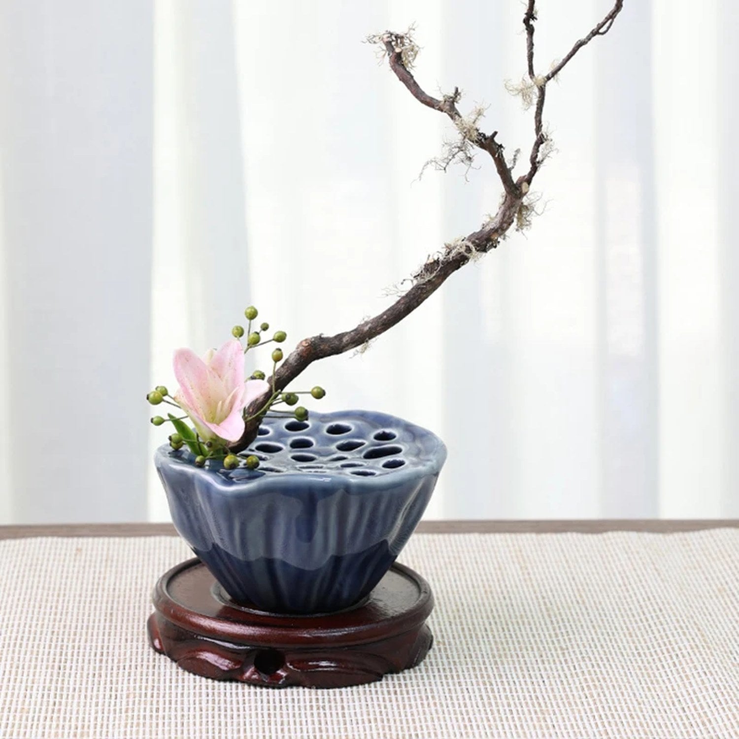 Vase Ikebana lotus bleu foncé en céramique avec branche de prunier et fleur sur support en bois