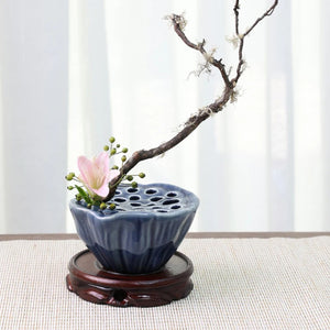 Vase Ikebana lotus bleu foncé en céramique avec branche de prunier et fleur sur support en bois