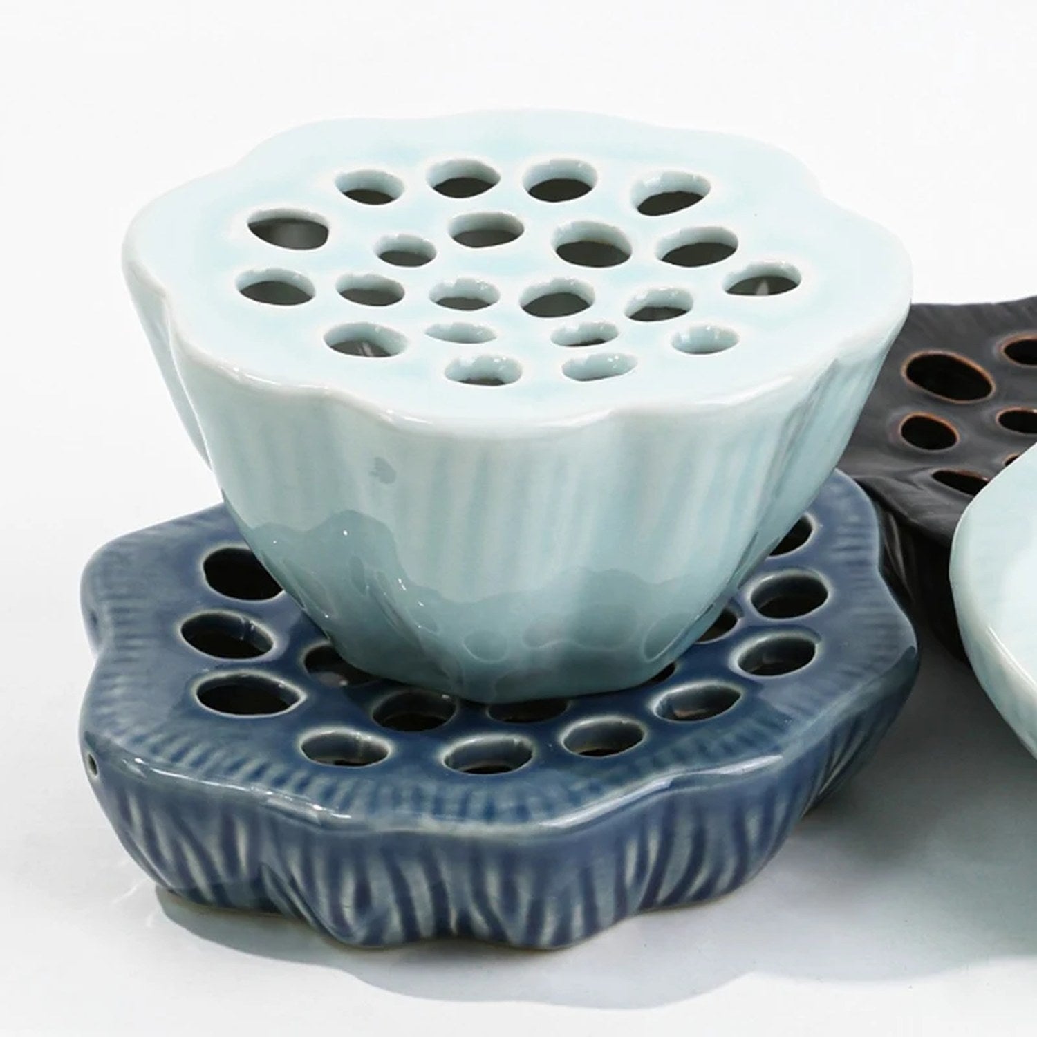 Vase Ikebana lotus céladon et disque plat bleu foncé vue rapprochée fond blanc