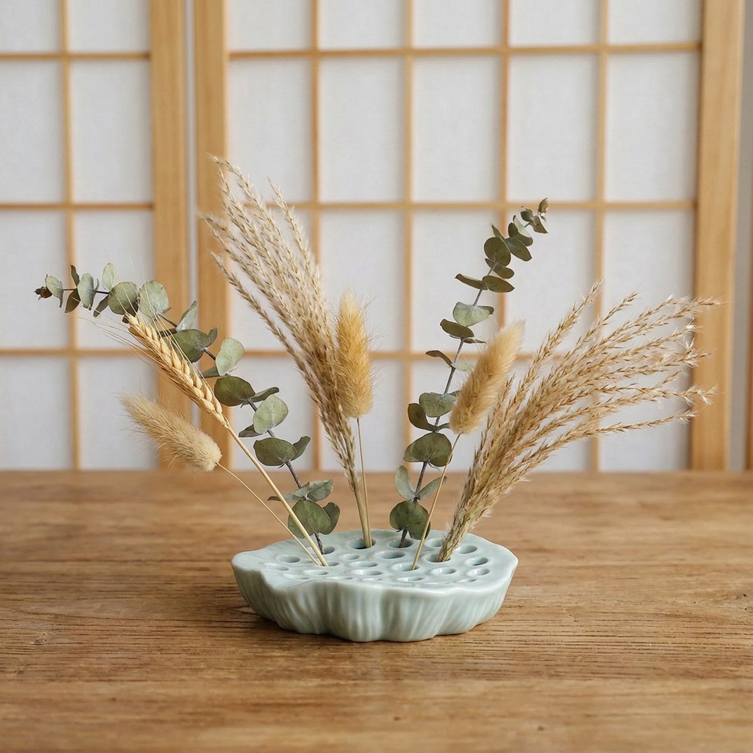 Vase Ikebana disque plat en céramique céladon avec pampas et branches séchées sur table japonaise