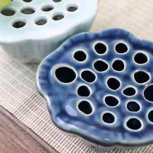 Gros plan vue de dessus du disque plat Ikebana bleu foncé orifices multiples céramique céladon arrière-plan
