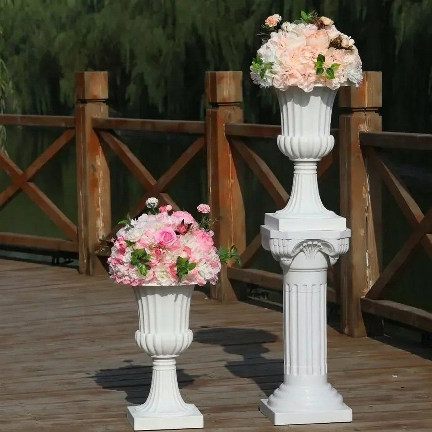 Vase médicis blanc dans un jardin fleuri avec des fleurs colorées en arrière-plan