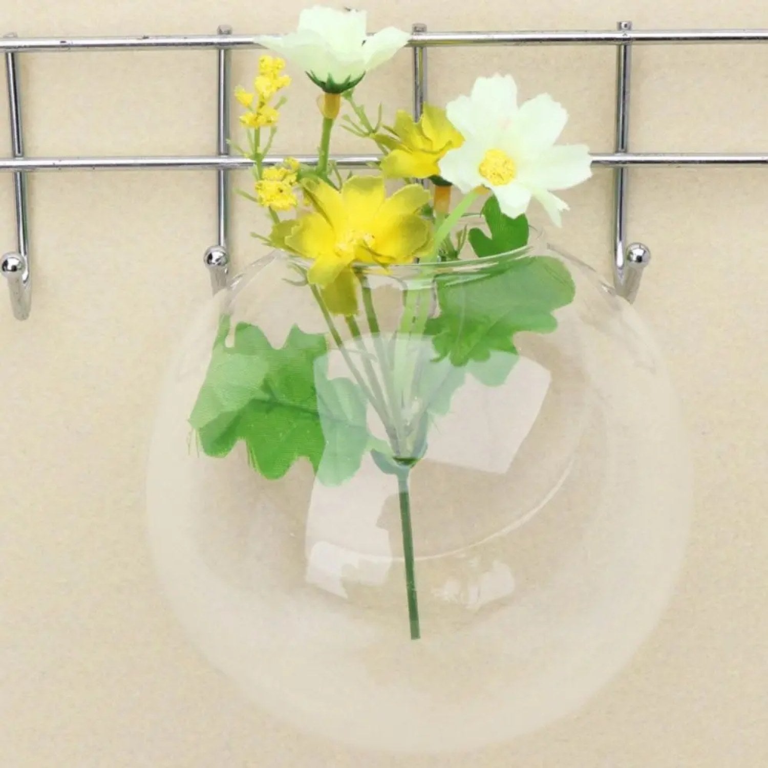 Vase mural en verre suspendu à une grille métal avec fleurs séchées