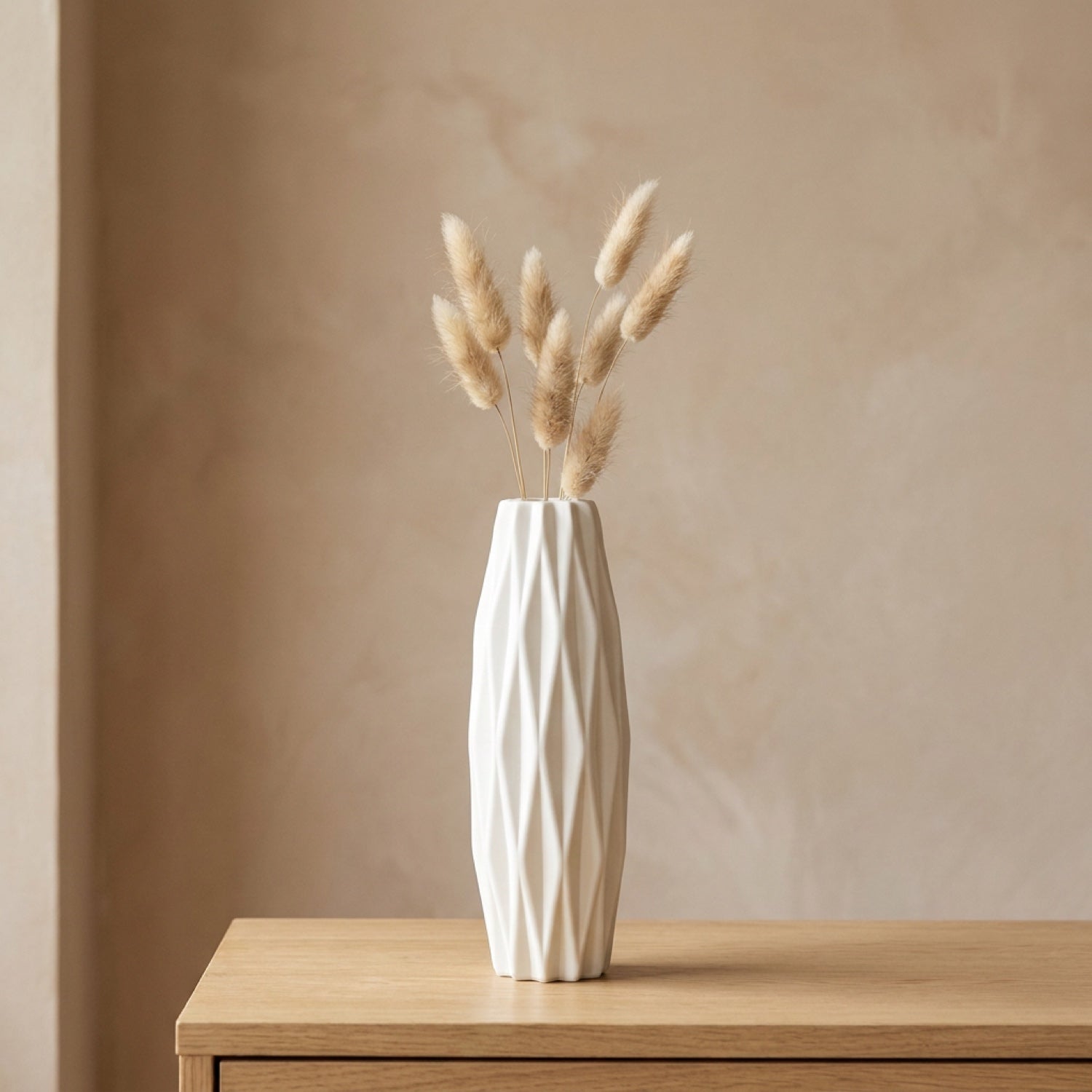 Vase blanc scandinave texture origami plissée avec des pampas posé sur une console en bois