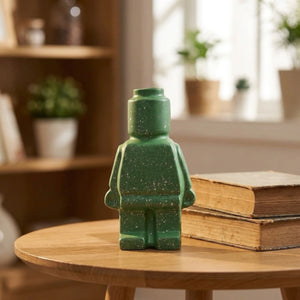 Vase robot céramique vert moucheté sur table ronde en bois avec livres anciens