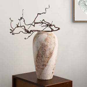 Vase en céramique wabi sabi modèle haut avec branches sur un meuble