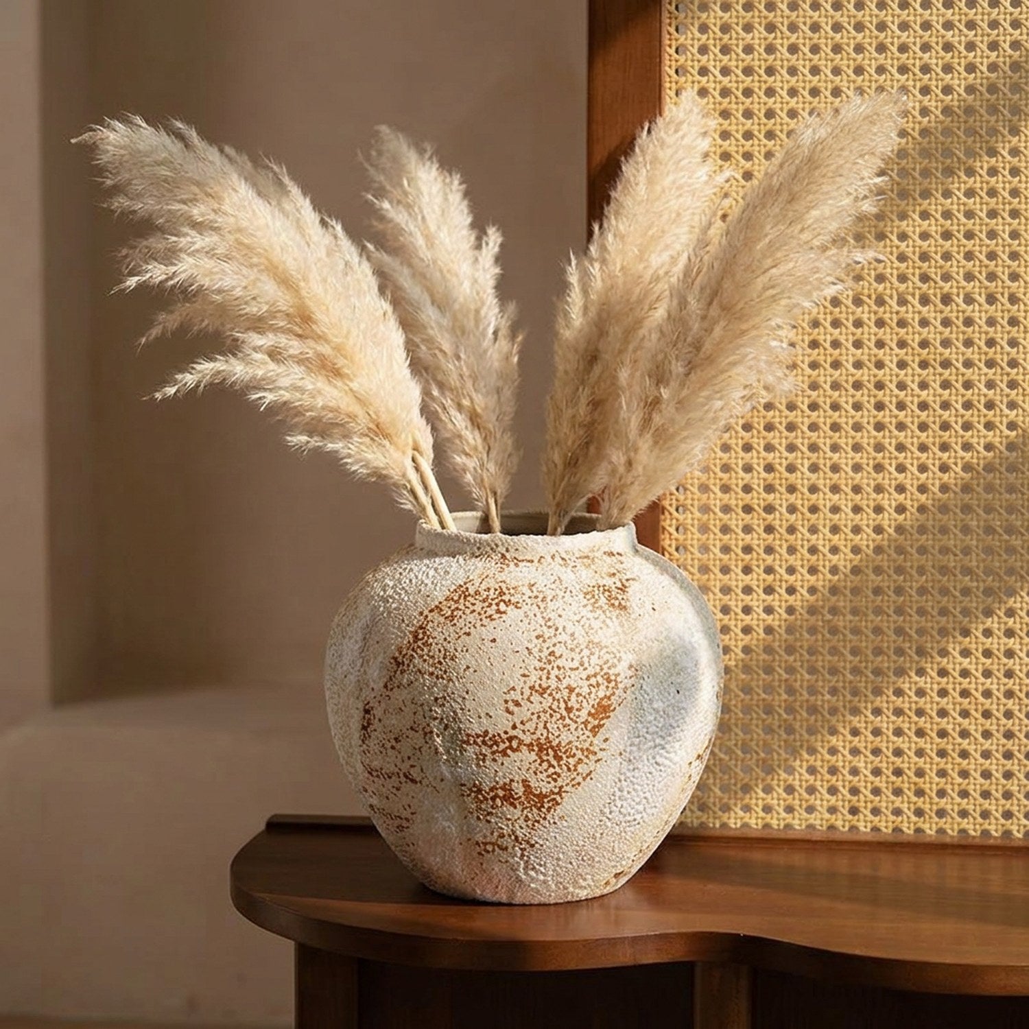 Vase en céramique wabi sabi rond avec herbes de la pampa sur une console en bois