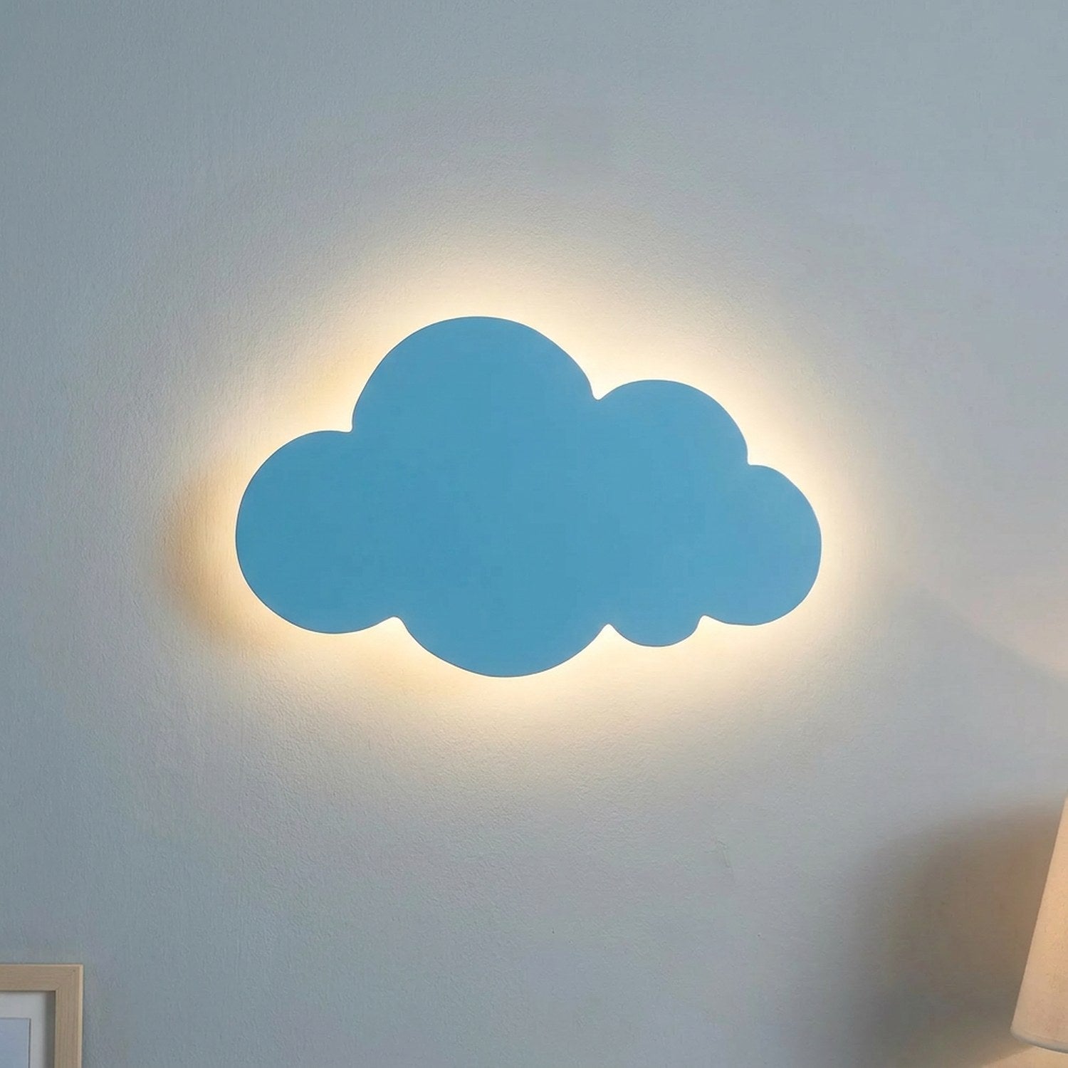 Applique murale nuage bleue allumée sur un mur de chambre d'enfant