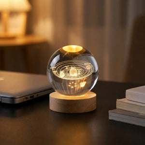 Lampe boule de cristal système solaire allumée sur un bureau