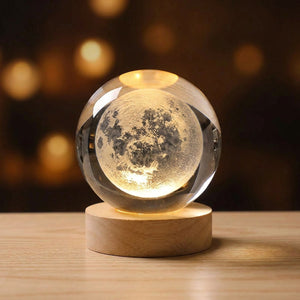 Lampe boule de cristal motif lune 3D allumée sur socle en bois