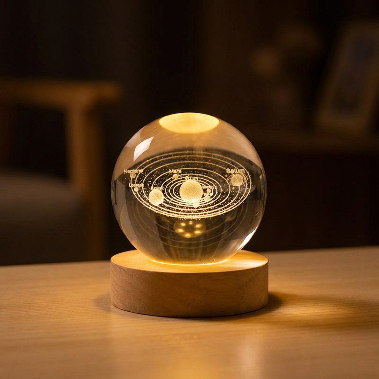 Lampe boule de cristal motif système solaire 3D allumée sur socle en bois