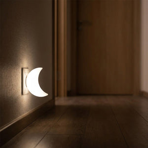 Veilleuse lune LED allumée dans un couloir en bois la nuit
