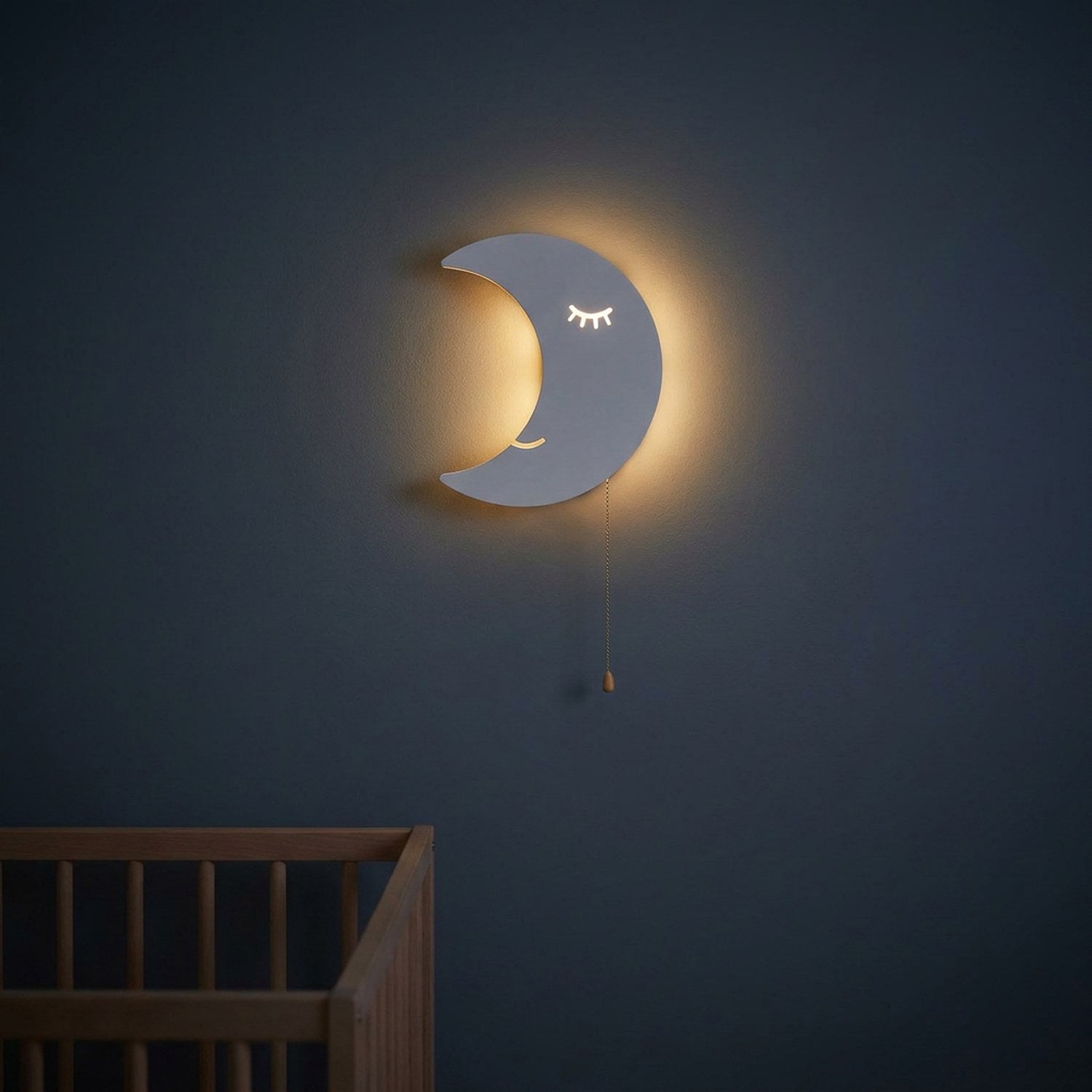 Veilleuse murale lune allumée la nuit au-dessus d'un lit à barreaux dans une nursery
