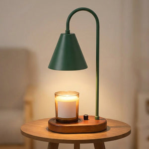 Lampe chauffe-bougie verte avec socle en bois allumée sur une petite table