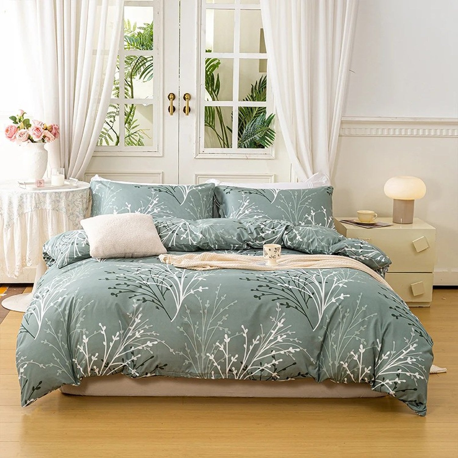 Parure de lit fleurie coloris vert sur un lit fait