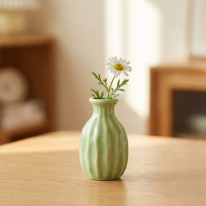 Vase soliflore en céramique côtelé vert avec une fleur unique
