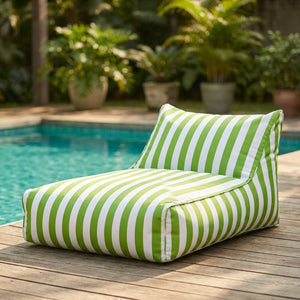 Pouf géant flottant à rayures verte posé au bord d'une piscine