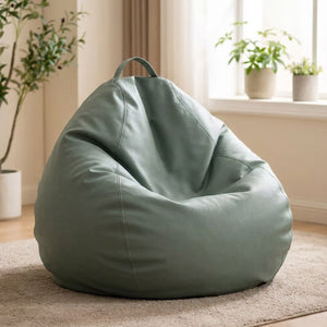 Pouf poire en simili cuir vert sauge posé au sol dans un intérieur cosy