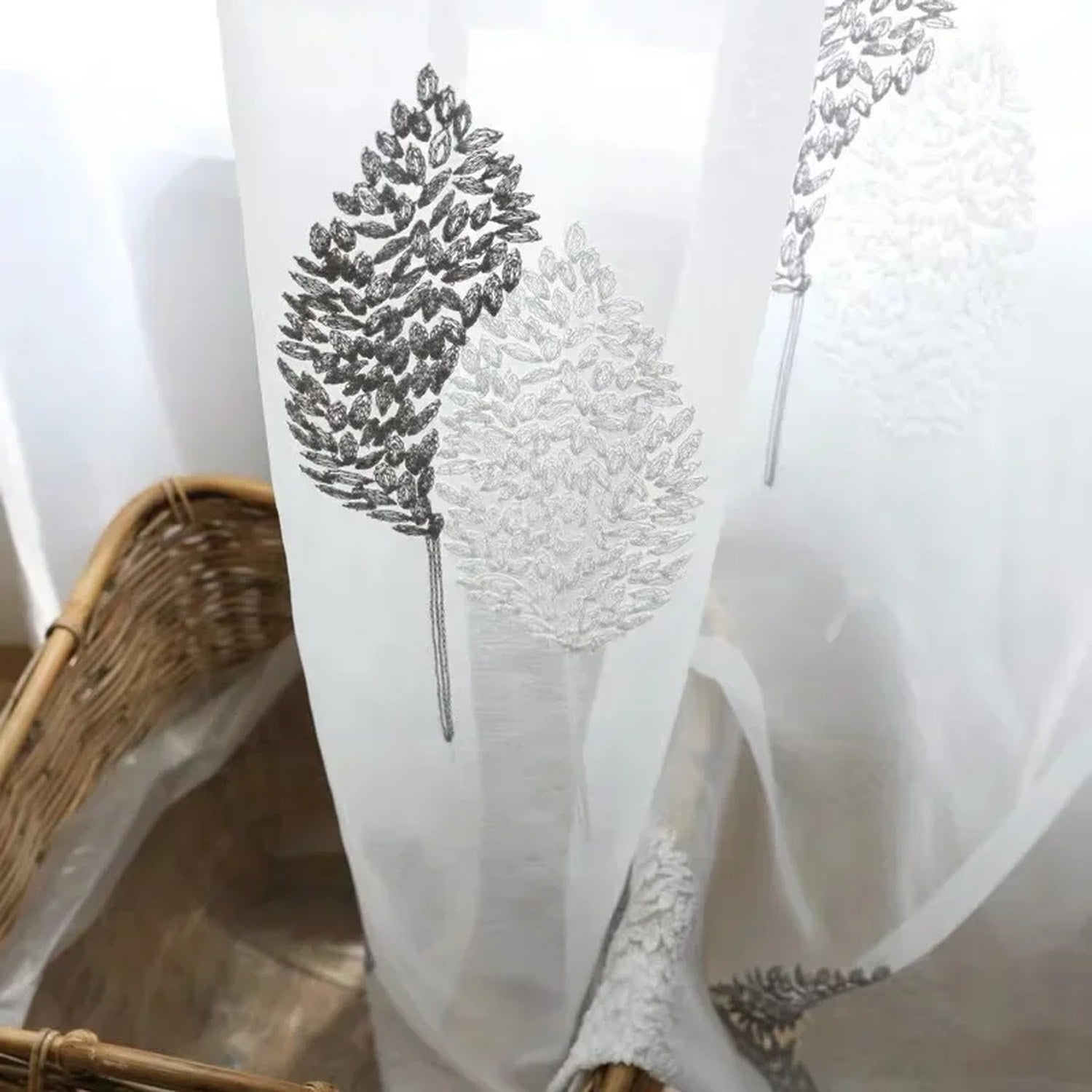 Gros plan des arbres brodés gris et blancs sur le voilage en tulle