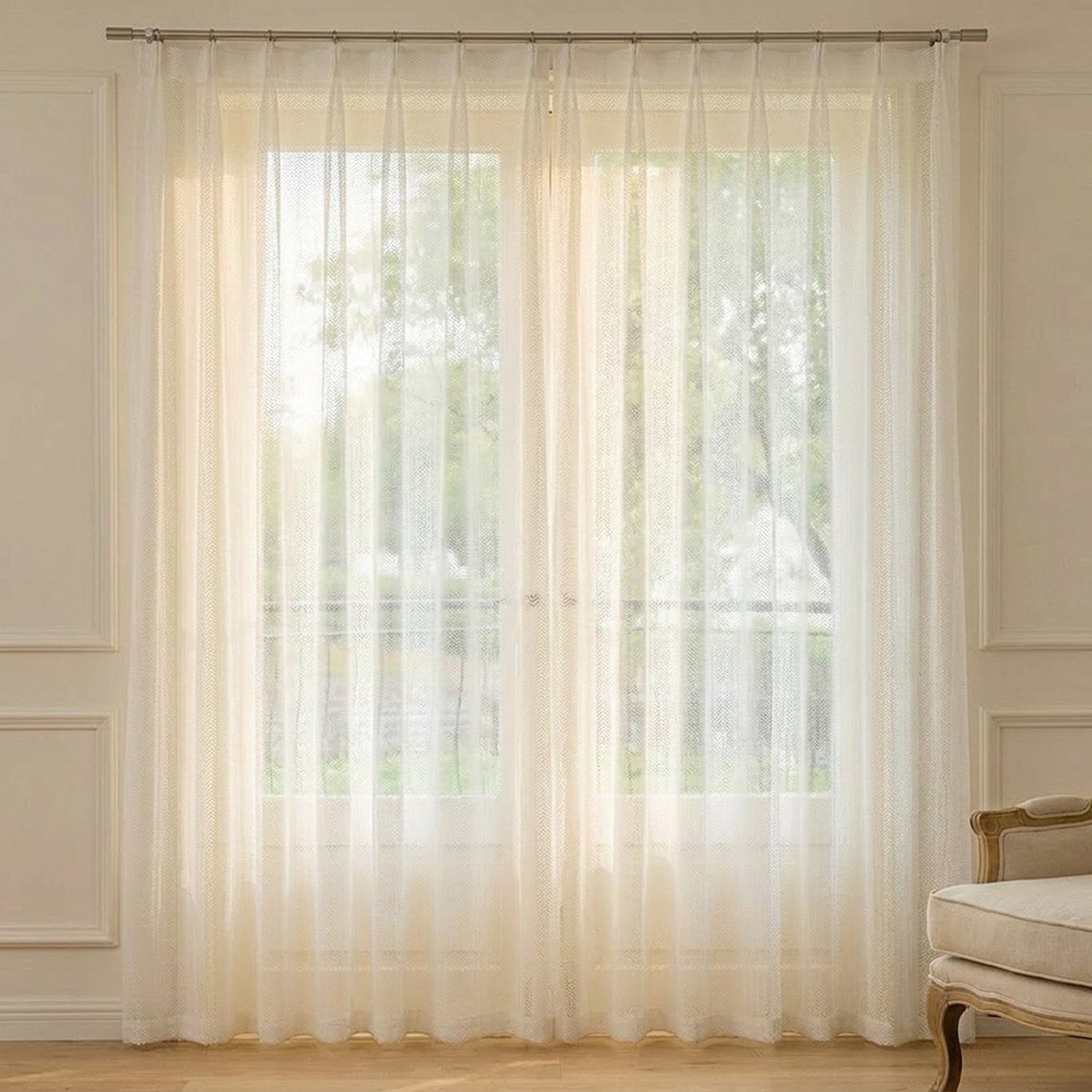 Voilage en tulle blanc à texture chevron suspendu devant une fenêtre lumineuse dans un intérieur chaleureux