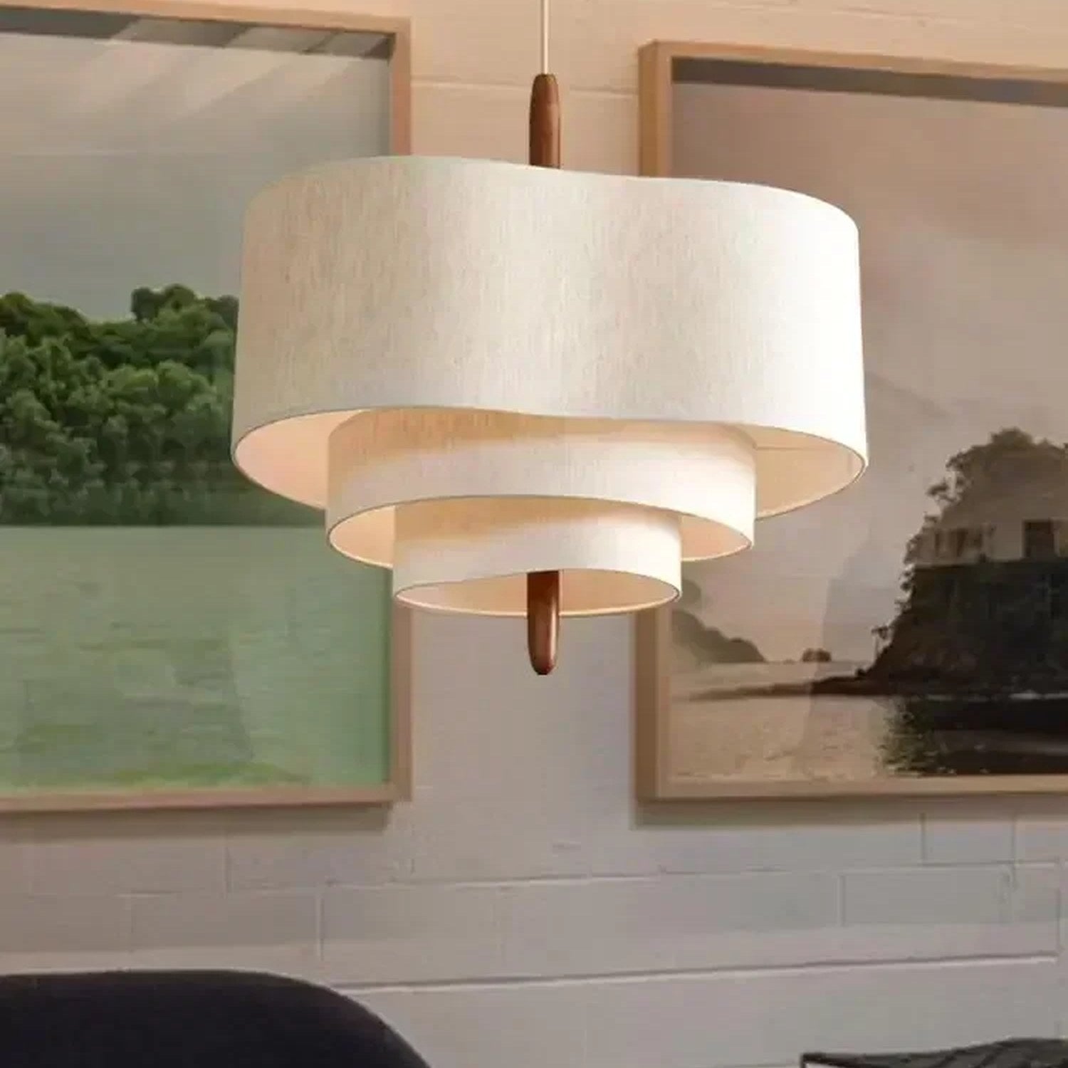 Suspension wabi sabi en lin écru vue de face devant des cadres décoratifs