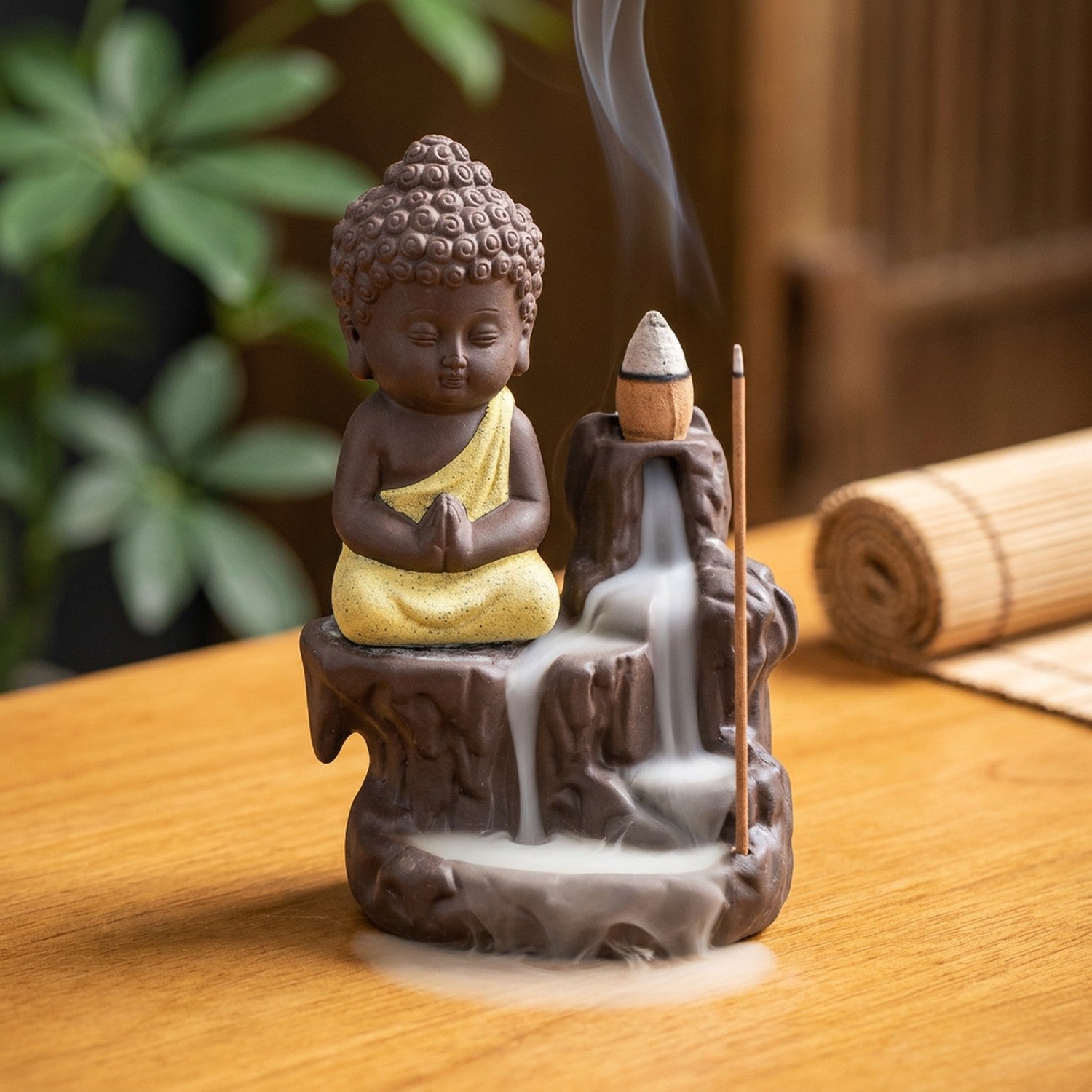 Brûleur d'encens à reflux en céramique avec petit moine bouddha à la robe jaune et cascade de fumée